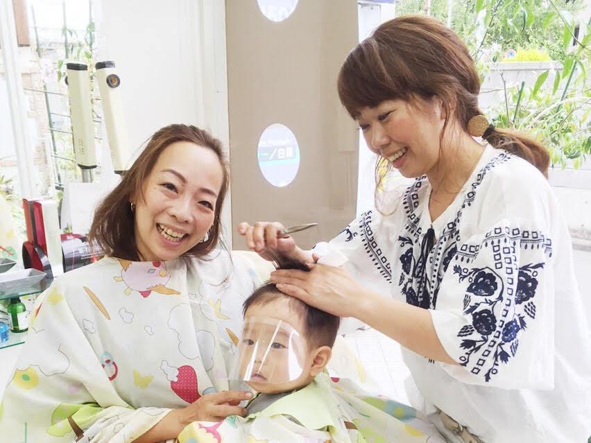 スタイリストがお子様の髪をカットしているサロンの温かな雰囲気